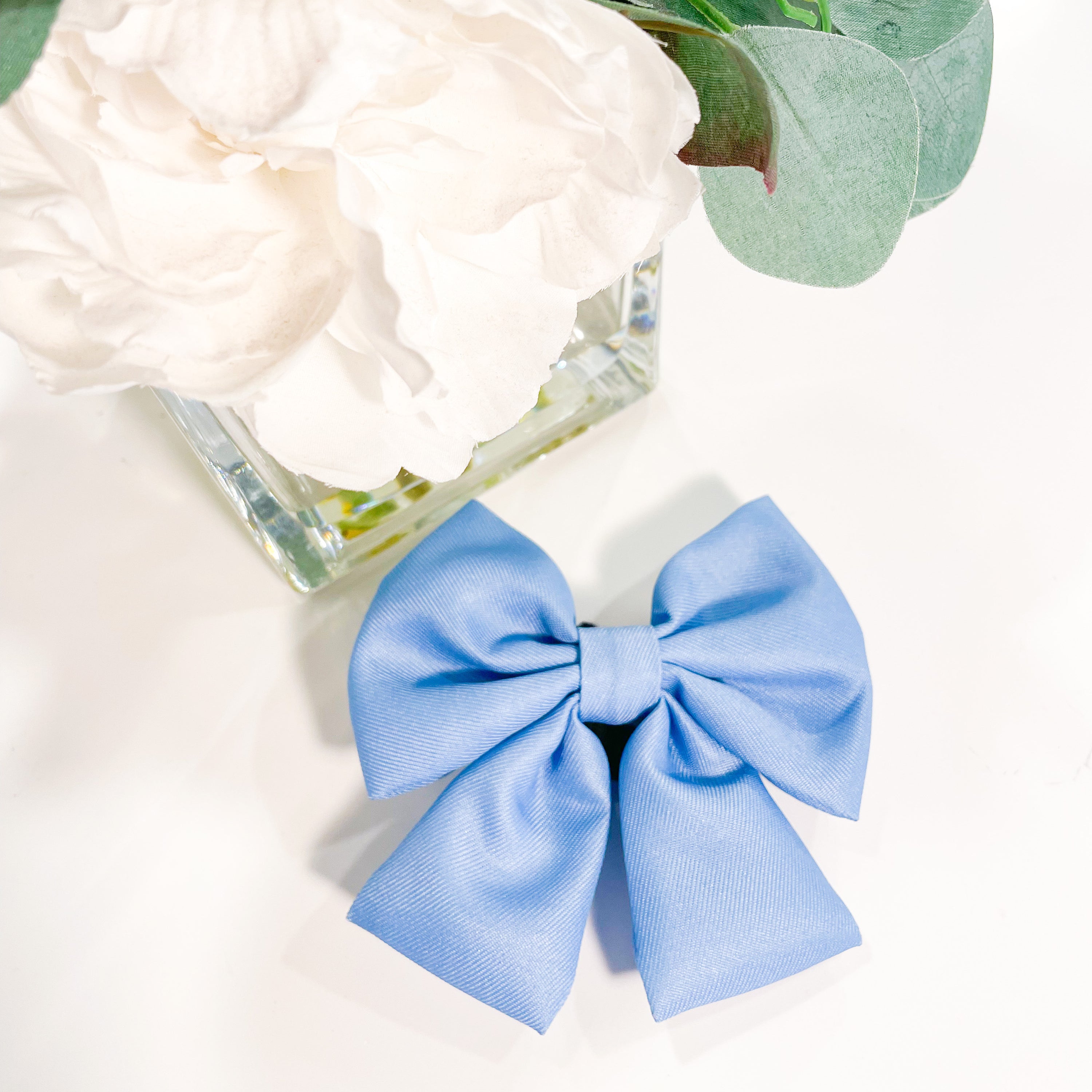 A vibrant sapphire blue bowtie for pets, featuring a Velcro strap for easy attachment to collars, perfect for stylish outings.